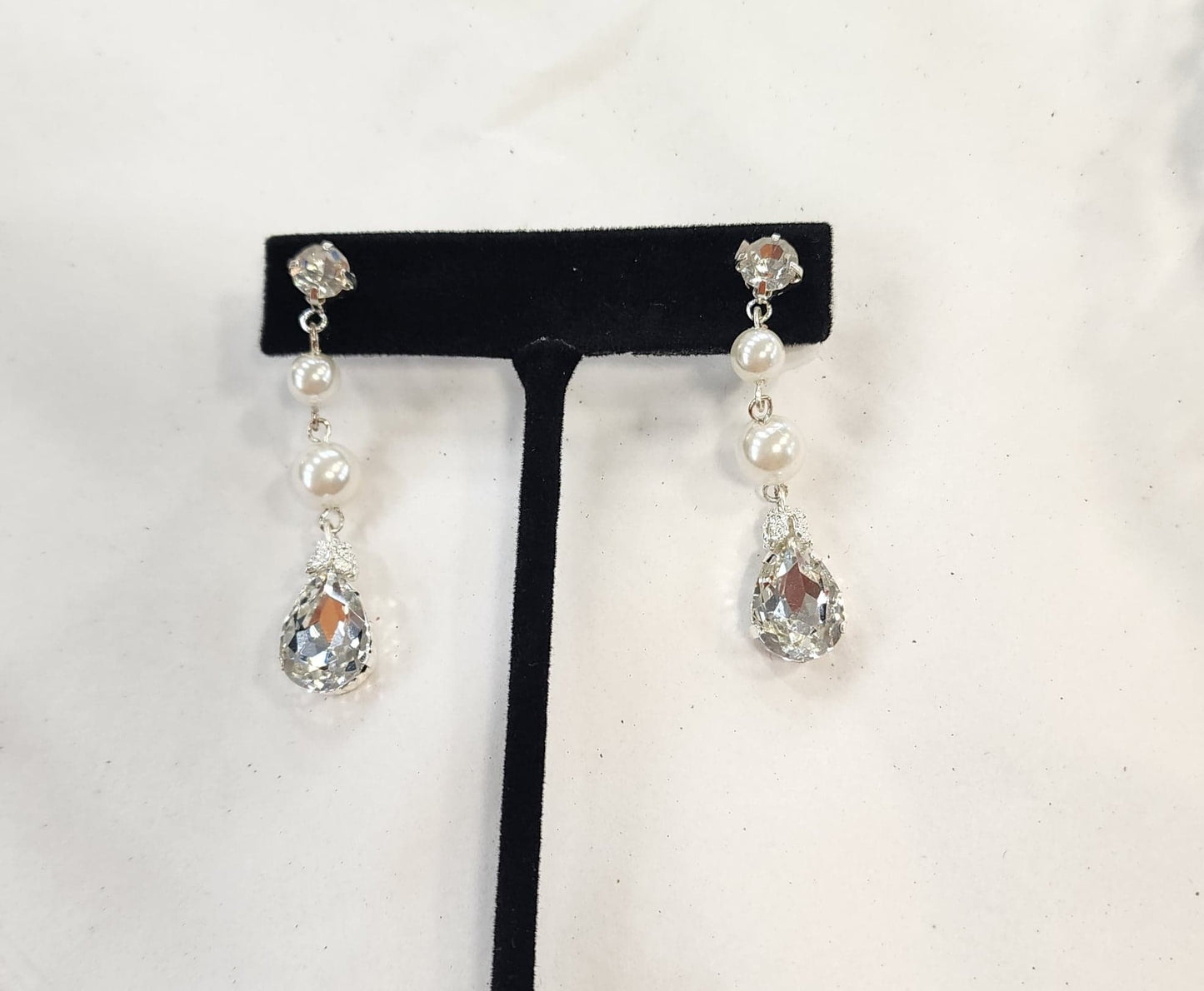 Pearl drop crystal earrings Lustrous, hanging double pearl drops and pear-cut rhinestones glimmer with delicate, glamorous detail! Perfect as a light embellishment for a wedding in any season.